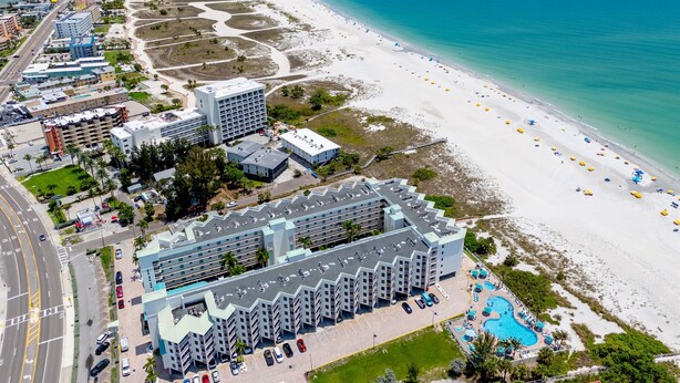 An aerial view of a coastal hotel with a beachfront, parking, and a swimming pool. - Treasure Island Gulf Front Condo Ocean Views (Treasure Island)