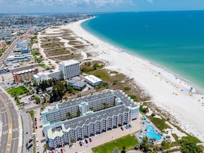 An aerial view of a coastal hotel with a beachfront, parking, and a swimming pool. - Treasure Island Gulf Front Condo Ocean Views (Treasure Island)
