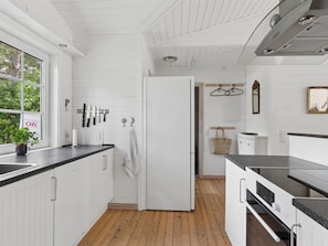 Eine moderne Küche mit weißen Schränken, einer schwarzen Arbeitsplatte und Holzboden.