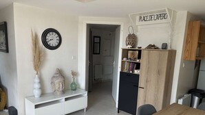Eine moderne Küche mit einem Holzespeisetisch, einem weißen Schrank, einer Uhr und einem Schild mit der Aufschrift 'PLACE DE LAPERO'.