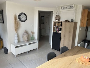 Eine moderne Küche mit einem Holzespeisetisch, einem weißen Schrank, einer Uhr und einem Schild mit der Aufschrift 'PLACE DE LAPERO'.