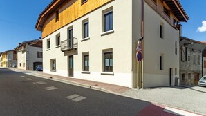 Ein zweistöckiges Gebäude mit einem Balkon, einem Fußgängerüberweg-Schild und einem Verbotsschild für Parken.