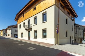 Um edifício de dois andares com varanda, sinal de faixa de pedestres e placa de proibido estacionar.