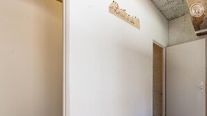 Ein Korridor mit einem Holzschild, einer Tür und einer Decke mit freiliegenden Balken.