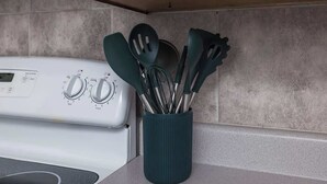 Una cucina con un piano cottura bianco, un portauovi verde acqua e uno schienale piastrellato.