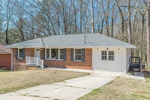Ein eingeschossiges Haus mit Veranda, Garage und kleinem Vorgarten.