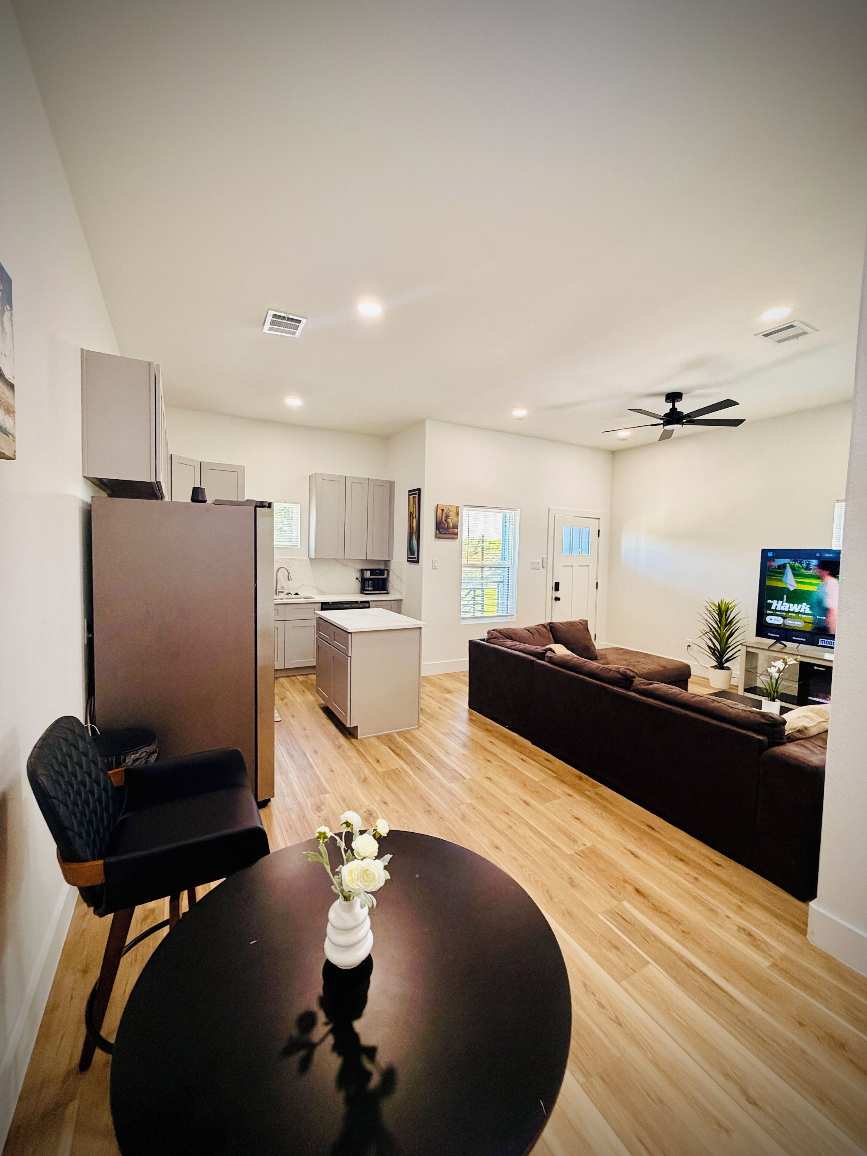 A modern living space with a kitchen, dining area, and seating area.