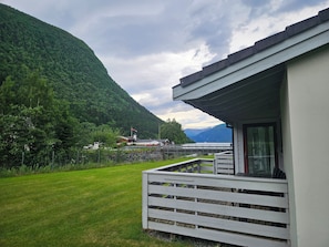 A hotel with a balcony overlooking a lush green landscape and mountains.