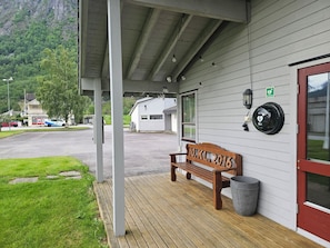 A wooden bench outside a building with a sign reading 'HO KL 2016'.