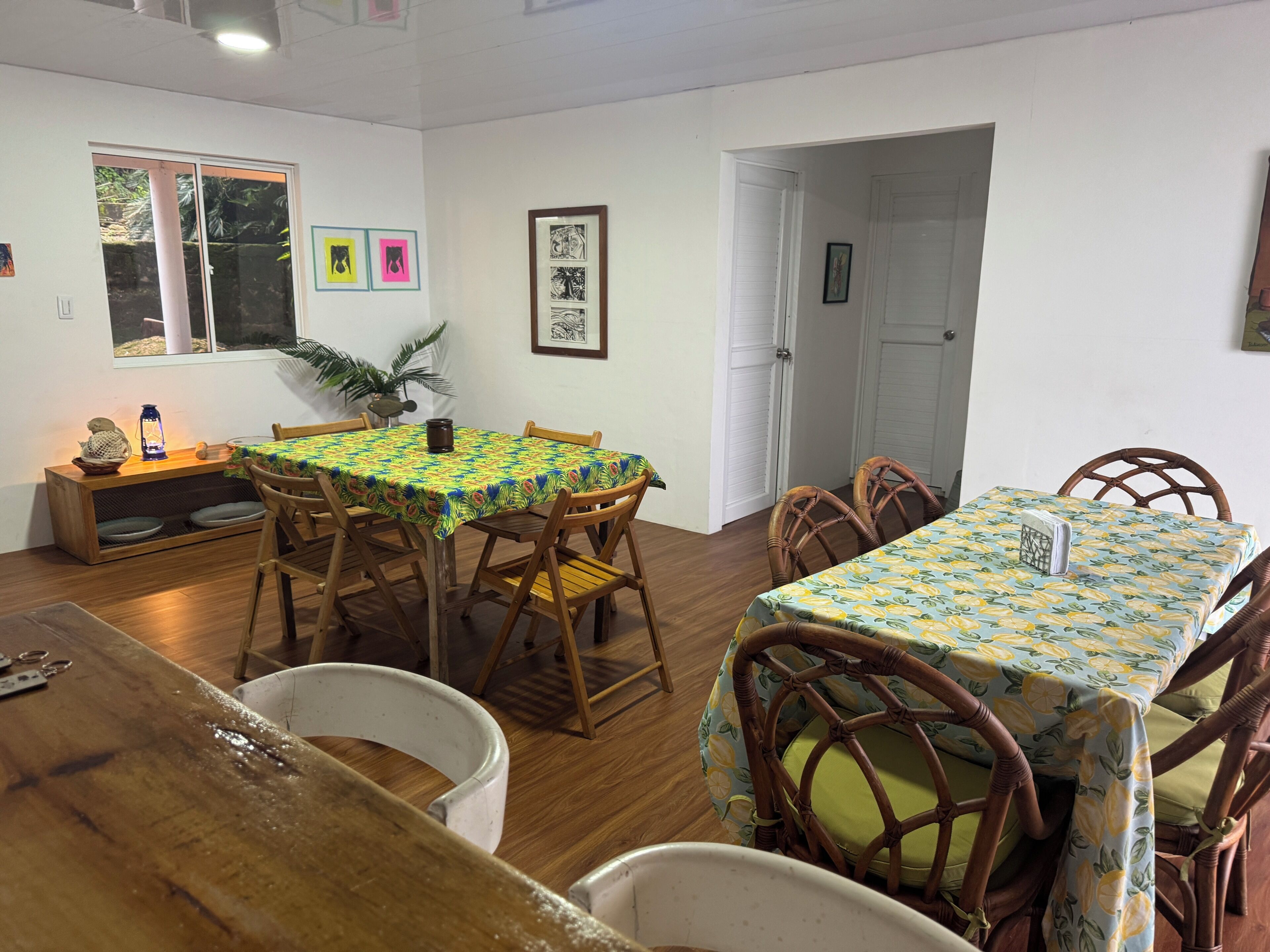 A dining area with a table and chairs, a window, and a door.