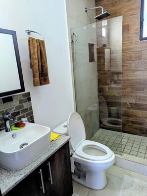 Ein Badezimmer mit Waschbecken, Toilette und einer Duschkabine.