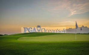 Un parcours de golf avec une grande enseigne indiquant « PGA Ocean’s 4 ».