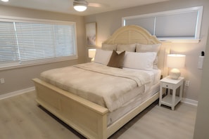 A bedroom with a bed, bedside lamps, and a window with blinds. - Boca Ciega Isle 3BR | Pool + Walk to Beach | Private House (St Pete Beach)