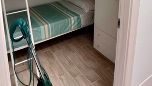 Et værelse med køjeseng og en støvsuger i hjørnet.