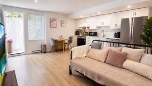 A modern apartment with a kitchenette, a dining area, and a bed. - Cozy South Surrey Private One-Bedroom - 2 beds - (Surrey)