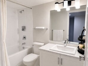 Uma casa de banho moderna com banheira, sanita e lavatório.