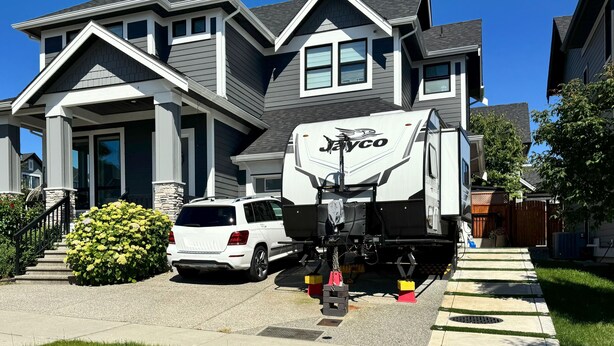 A residential house with a covered driveway, a parked white SUV, and a Jayco RV. - Cozy South Surrey Private One-Bedroom - 2 beds - (Surrey)