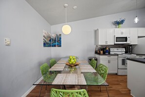 Une cuisine moderne avec des meubles blancs, un four à micro-ondes et une cuisinière.