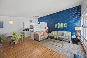 A modern living room with a sofa, coffee table, and dining area.