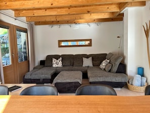 A cozy living area with a sectional sofa, a dining table, and chairs. - Ferienhaus La Trapla, (Samnaun-Compatsch) by Interhome (Samnaun)