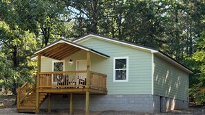 A single-story house with a wooden deck and a covered porch.