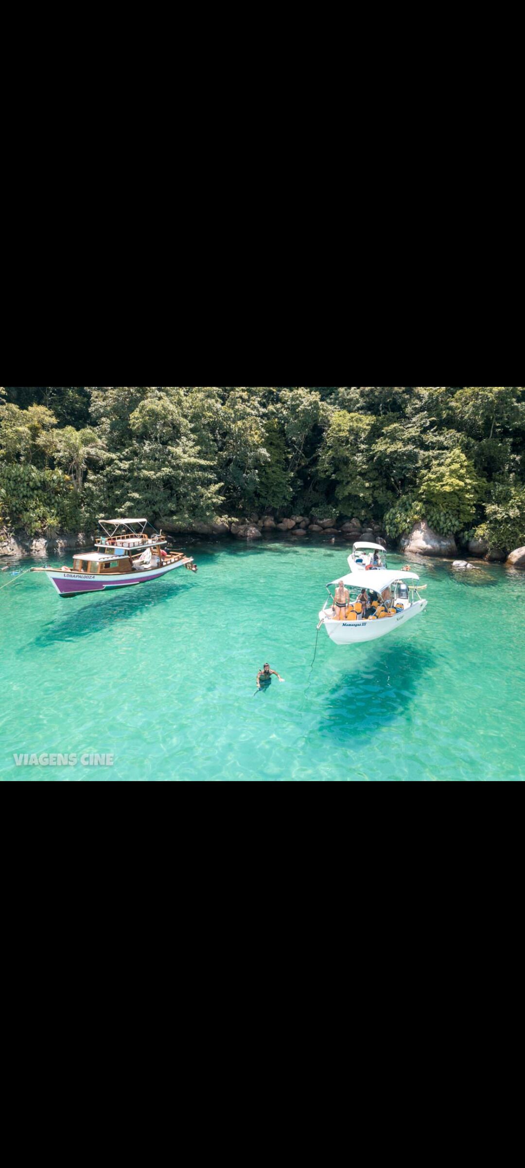 Una barca su un mare turchese con un’isola boscosa sullo sfondo.