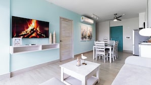 A modern living room with a flat-screen TV, white furniture, a ceiling fan, and an air conditioning unit. - CASA PARAISO: Spacious 3-bedroom cozy apartment just a few meters from the ocean (Chame)