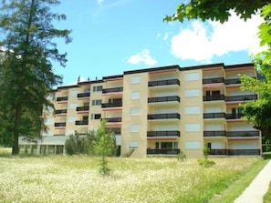 A multi-story building with balconies, surrounded by grass and trees. - Brentsch Park, (Scuol) by Interhome (Scuol)