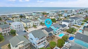 A coastal residential area with multiple two-story houses, a beach in the background, and a blue pin indicating a location. - 4 Bedroom, 4 Bathroom, Dunes Home, PET FRIENDLY (Supply)