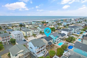A coastal residential area with multiple two-story houses, a beach in the background, and a blue pin indicating a location. - 4 Bedroom, 4 Bathroom, Dunes Home, PET FRIENDLY (Supply)