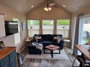 A cozy living room with a dark blue sofa, a wooden coffee table, and a ceiling fan. - Walkable view location







Walkable view location, cozy stay (Wrangell)