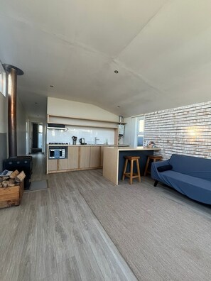 Et moderne køkken med indbygget komfur, en træbordplade og en bar.