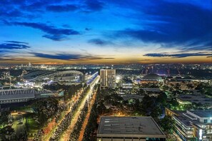 A cityscape at dusk with a stadium, roads, and buildings.