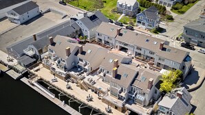An aerial view of a waterfront property with multiple buildings, docks, and a marina.