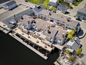 An aerial view of a waterfront property with multiple buildings, docks, and a marina.