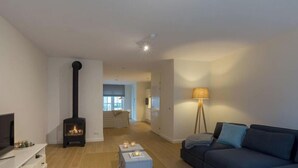 Un salon avec une cheminée, un canapé, une lampe et un téléviseur.