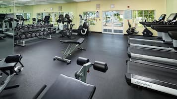 A gym with treadmills, elliptical machines, and free weights.