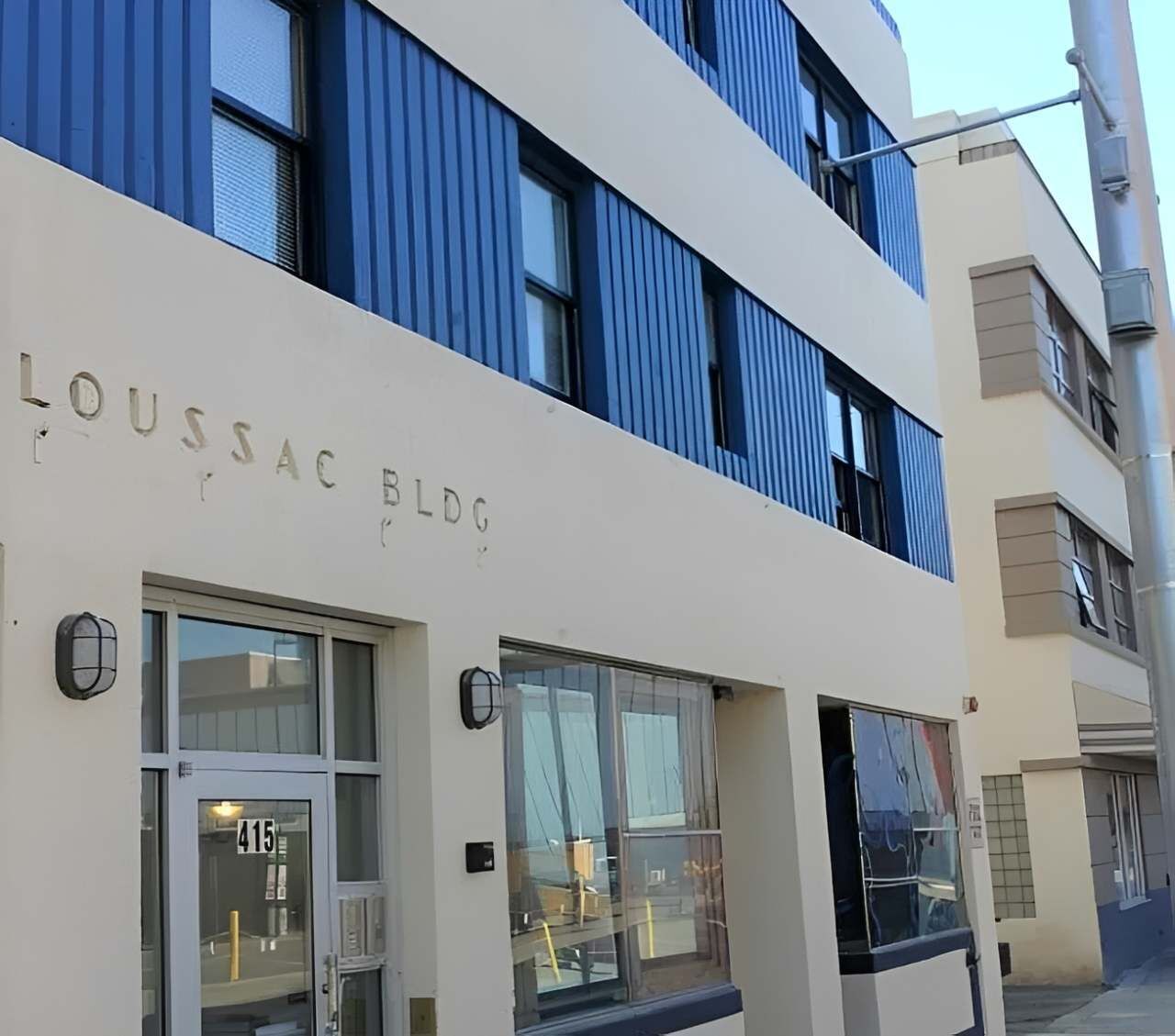 A building with the sign 'LOUSSAC BLDG' and a number '415' on the door.