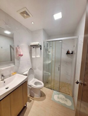 Une salle de bain moderne équipée de toilettes, d’un lavabo et d’une douche.