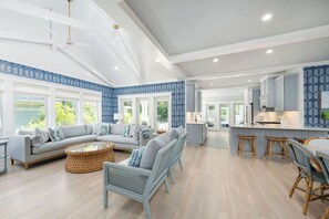 A spacious living room with a sofa, wicker chairs, and a coffee table. - Bald Head Island retreat, where coastal elegance meets relaxed island living (Bald Head Island)