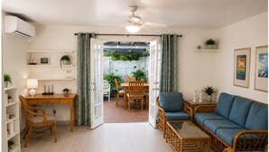 Ein Wohnzimmer mit Schreibtisch, Sofa und Essbereich.