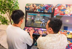 Deux personnes jouent à un jeu vidéo sur une console, avec un arriÚre-plan aux couleurs vives.