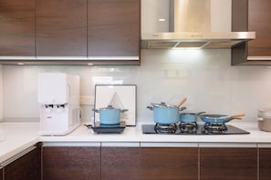 A modern kitchen with a water dispenser, a gas stove, and a range hood. - 42Pax 9BR Damansara Pool Villa by Verano (Kuala Lumpur)