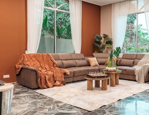 A living room with a brown sofa, a coffee table, and a rug.