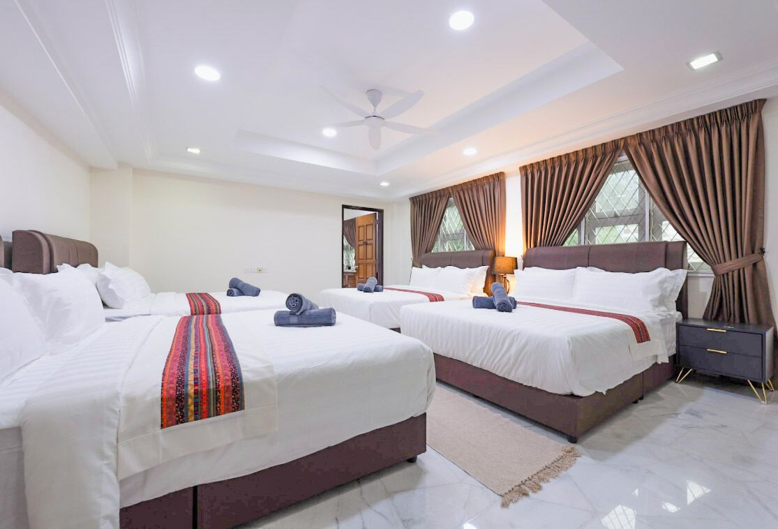 A hotel room with two beds, a ceiling fan, and a nightstand.