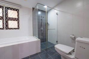 A bathroom with a glass-enclosed shower, a white bathtub, and a toilet. - 42Pax 9BR Damansara Pool Villa by Verano (Kuala Lumpur)