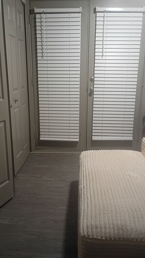 Un dormitorio con cama, dos puertas y un pasillo.