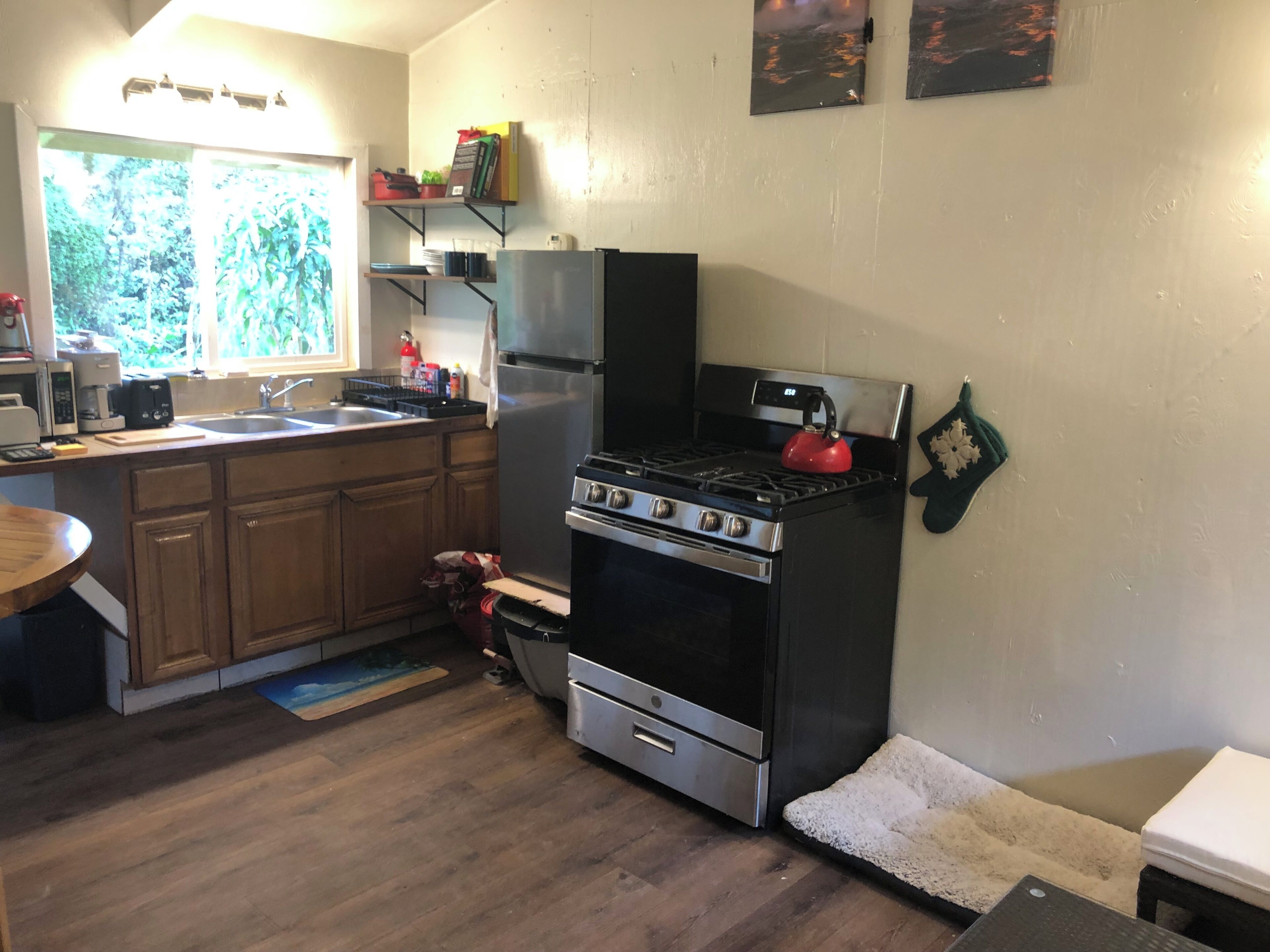 A kitchen with wooden cabinets, a stainless steel refrigerator, a gas stove, and a microwave.