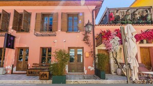 A pink building with wooden shutters, a bench, and a table outside. - Konak Lemon Guesthouse Heart of Vlora (Vlorë)