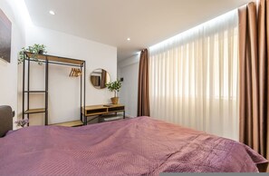 A bedroom with a bed, a desk, a mirror, a plant, and a wardrobe. - Konak Lemon Guesthouse Heart of Vlora (Vlorë)